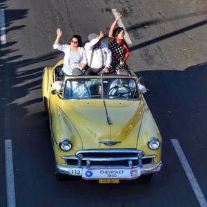 Un auto Chevrolet Styleline Deluxe Convertible de 1950 de color amarillo transitando el desfile.